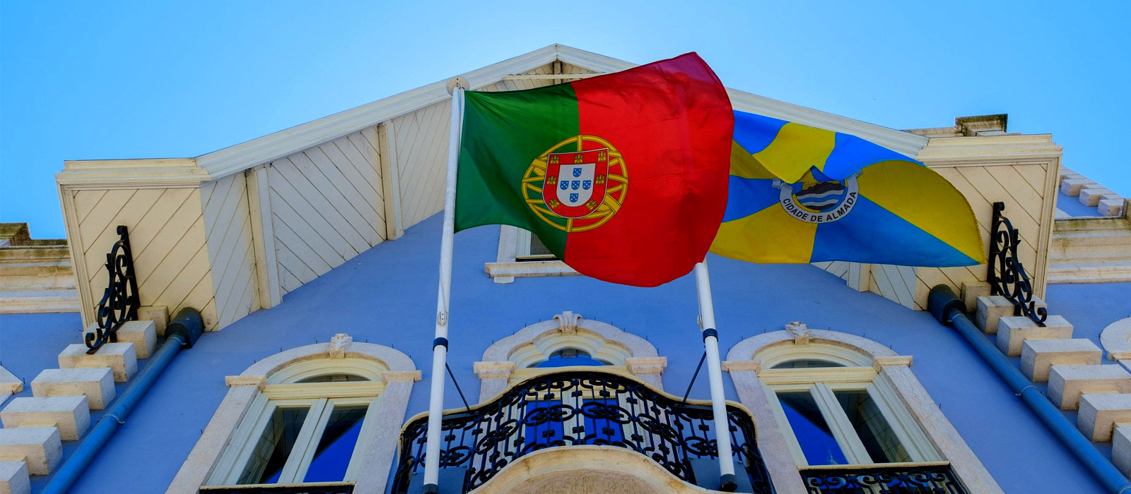 Bandeiras municipais portuguesas em frente a edifício público